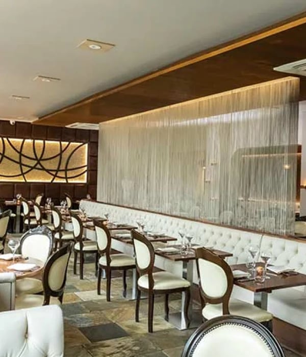 The dining room: white quilted banquettes and circular lattice screens